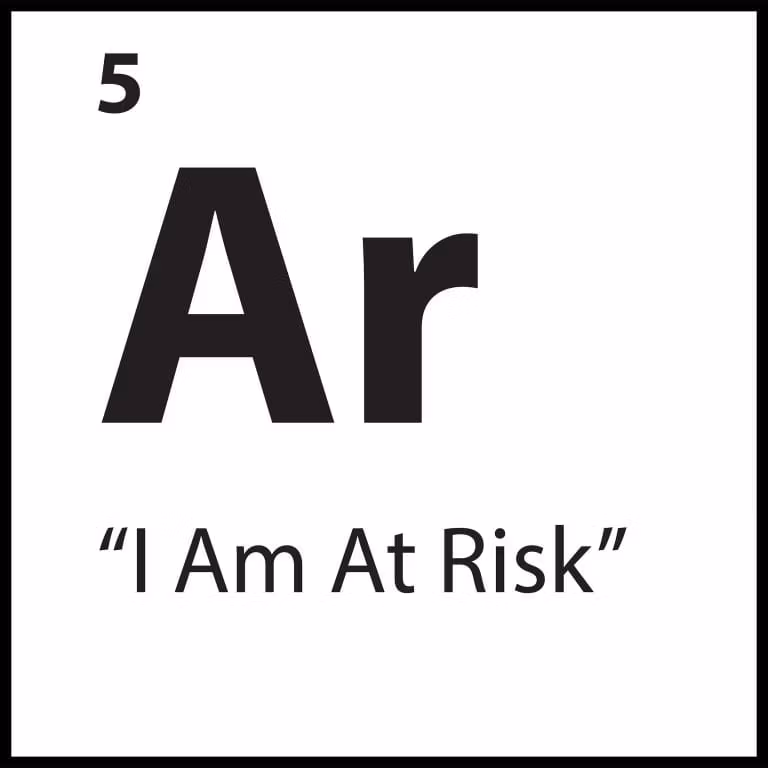 Limiting belief tile for “I Am At Risk” with an orange background, representing anxiety, vigilance, and safety-seeking behaviours.